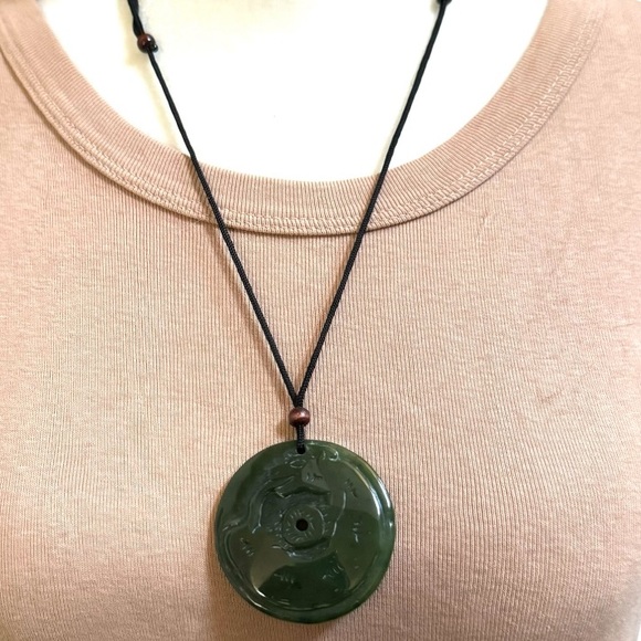 Carved jadeite pendant necklace on adjustable cord.